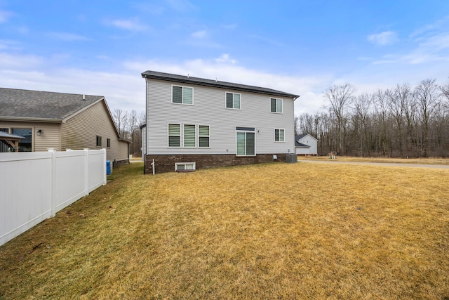 back of house with a lawn and fence