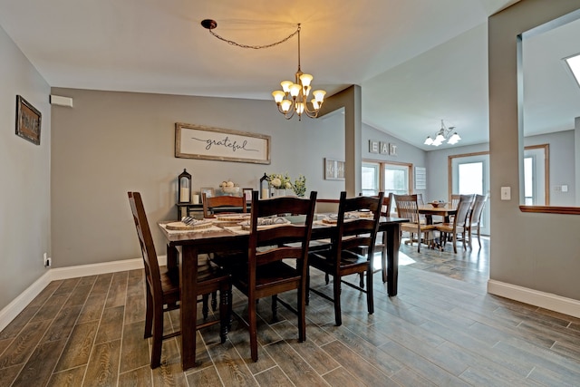 dining area featuring baseboards, wood finish floors, and an inviting chandelier