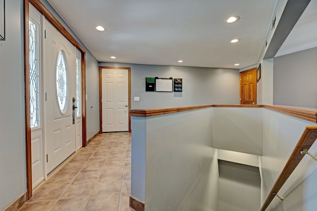 foyer featuring baseboards, light tile patterned flooring, and recessed lighting