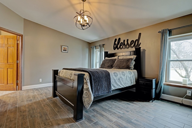 bedroom with lofted ceiling, an inviting chandelier, baseboards, and wood finished floors