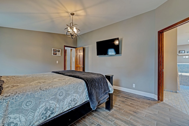 bedroom with baseboards, wood finish floors, and an inviting chandelier