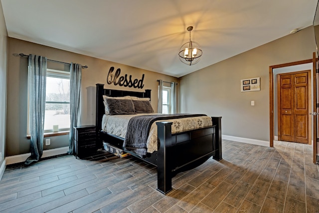 bedroom featuring wood finish floors, a notable chandelier, vaulted ceiling, and baseboards