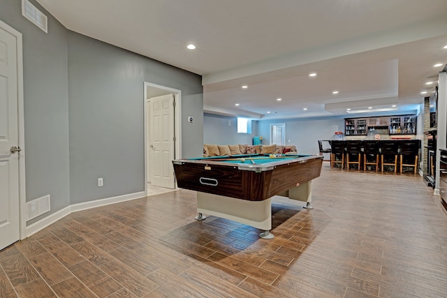 recreation room featuring a dry bar, wood finish floors, visible vents, and recessed lighting