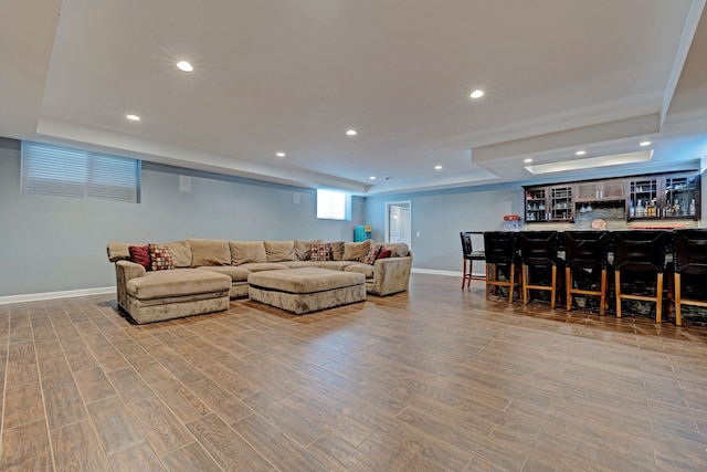 living room featuring a dry bar, baseboards, wood finished floors, and recessed lighting