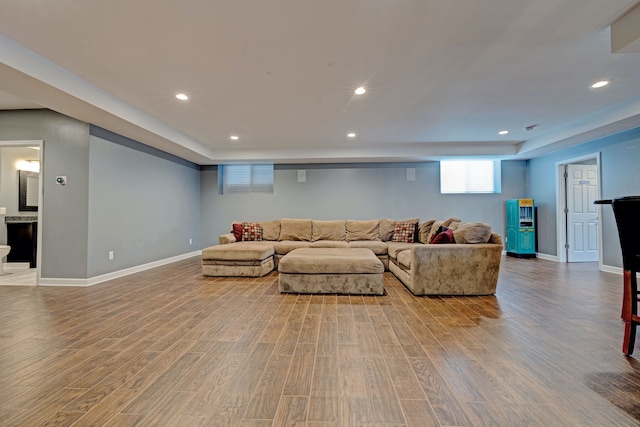 living area with baseboards, wood finished floors, and recessed lighting