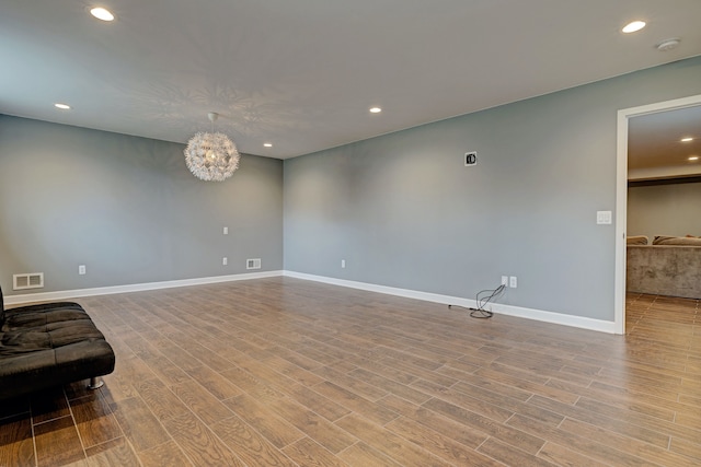 unfurnished living room featuring baseboards, visible vents, wood finished floors, and recessed lighting