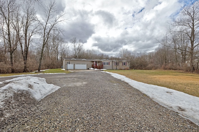 view of front of property with a garage, a front lawn, and gravel driveway