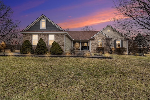 view of front of house with brick siding and a yard