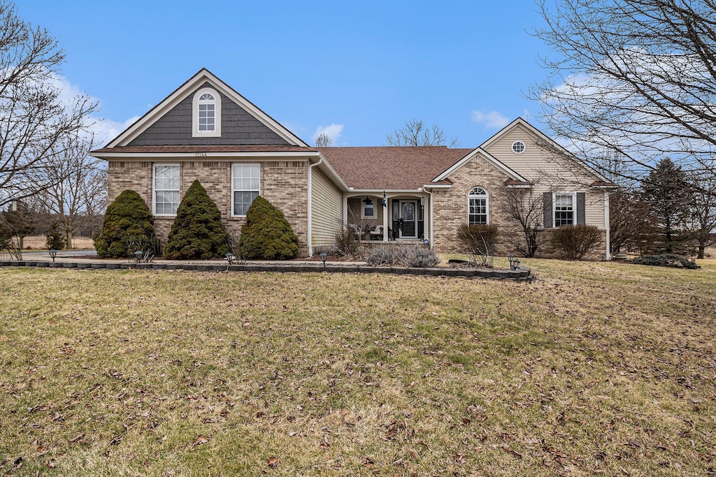 view of front of property featuring brick siding and a front yard