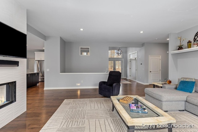 living room with recessed lighting, baseboards, dark wood finished floors, and a multi sided fireplace