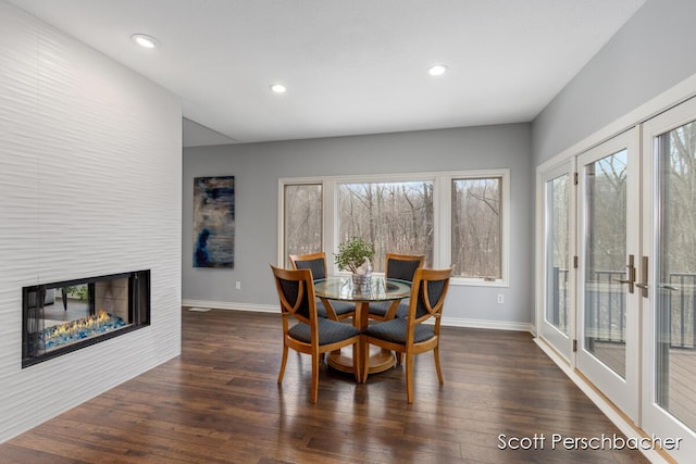 dining room with recessed lighting, a multi sided fireplace, dark wood finished floors, and baseboards