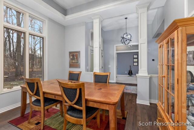 dining room with baseboards, dark wood-type flooring, an inviting chandelier, and ornate columns