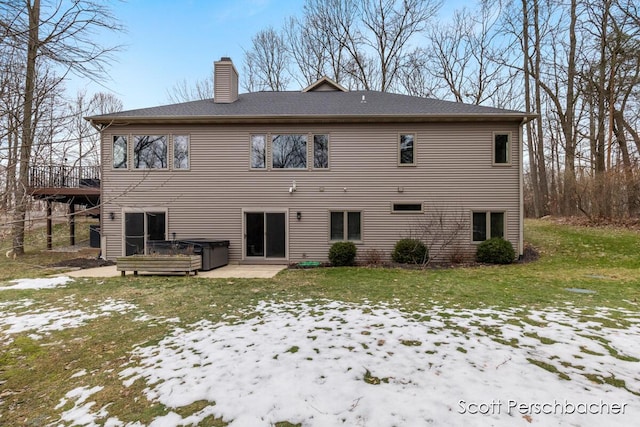 snow covered property featuring a hot tub, a yard, a chimney, and a wooden deck