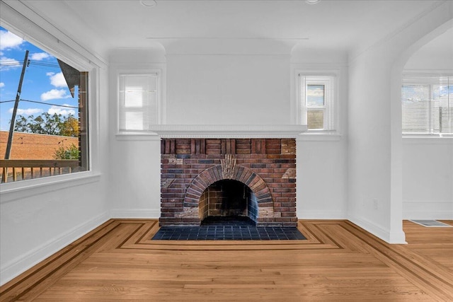 details featuring a fireplace, wood finished floors, and baseboards