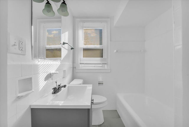 full bathroom featuring tile patterned floors, tile walls, toilet, and vanity