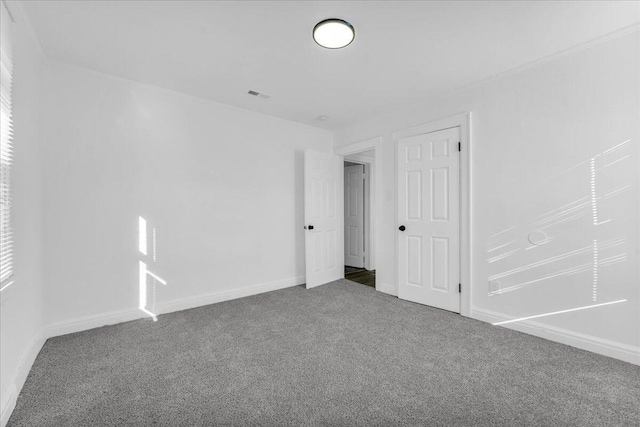 carpeted empty room featuring visible vents and baseboards