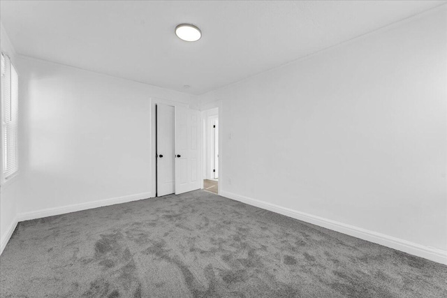 spare room with carpet and baseboards