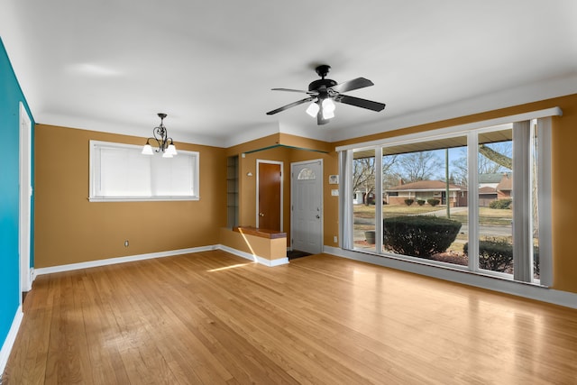 empty room featuring baseboards, light wood finished floors, and ceiling fan with notable chandelier