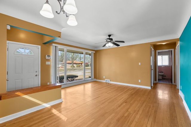 foyer entrance featuring light wood-style floors, visible vents, baseboards, and a ceiling fan