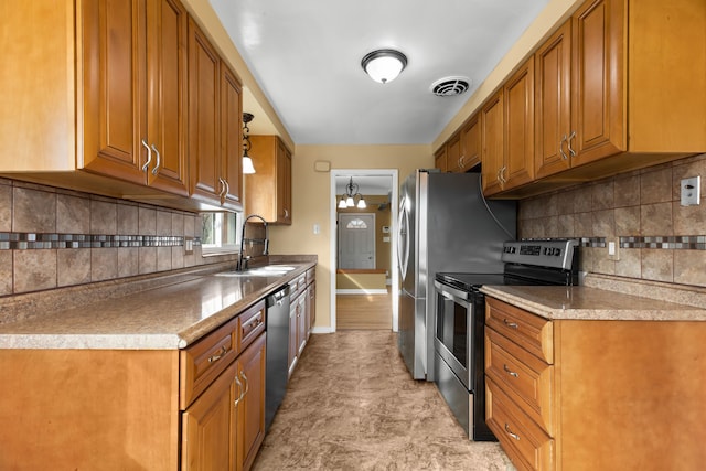 kitchen featuring stainless steel appliances, a sink, visible vents, and brown cabinets