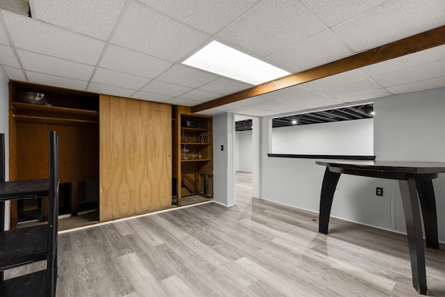 finished basement featuring a drop ceiling and wood finished floors