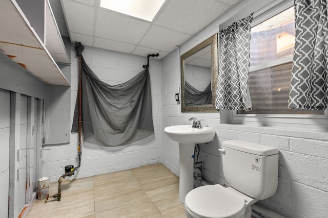 bathroom with concrete block wall and toilet