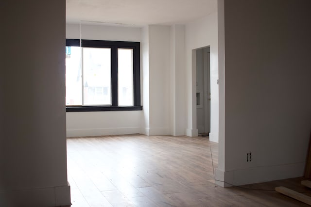 empty room featuring baseboards and wood finished floors