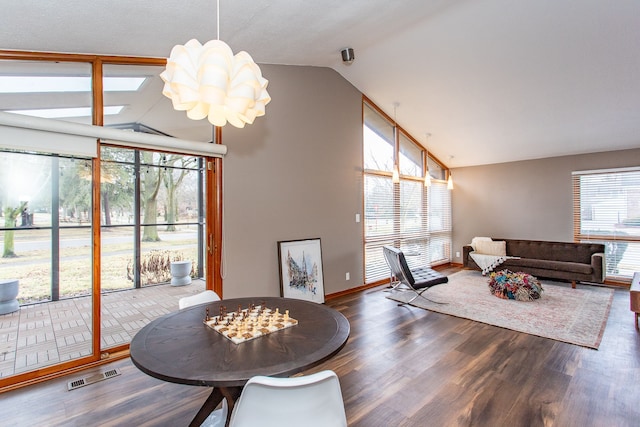 living room with high vaulted ceiling, wood finished floors, visible vents, and a notable chandelier