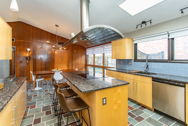 kitchen with black electric stovetop, island range hood, wood walls, a sink, and stainless steel dishwasher