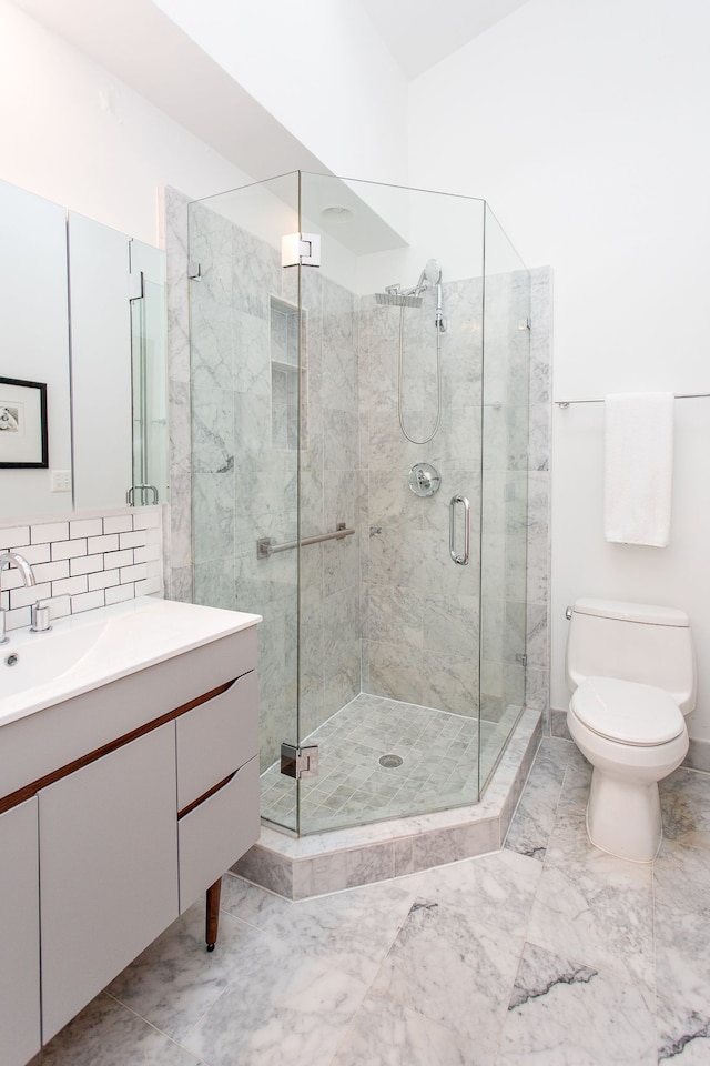 bathroom featuring tasteful backsplash, toilet, marble finish floor, vanity, and a shower stall