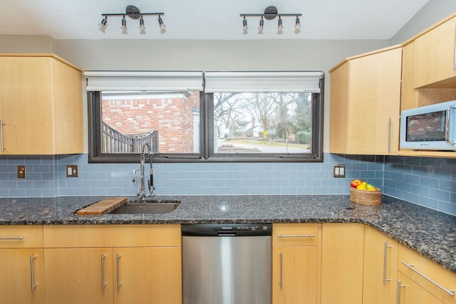 kitchen with tasteful backsplash, white microwave, light brown cabinets, a sink, and dishwasher