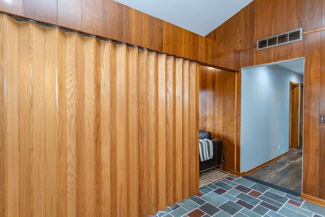 interior space featuring baseboards, visible vents, and wooden walls