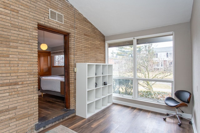 interior space featuring visible vents, vaulted ceiling, baseboards, and wood finished floors