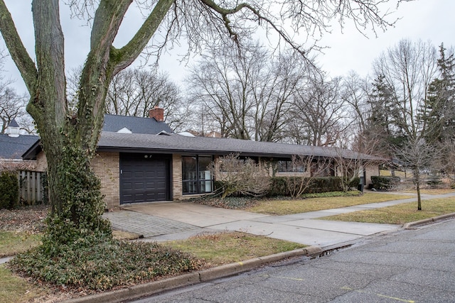 view of front of property with brick siding, roof with shingles, a chimney, concrete driveway, and a garage