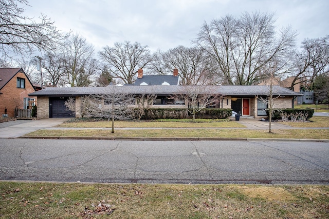 view of front of property with an attached garage, brick siding, concrete driveway, and a front yard