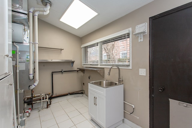 laundry area with light tile patterned floors, a sink, and cabinet space