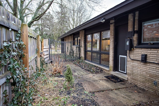 exterior space with brick siding and a fenced backyard