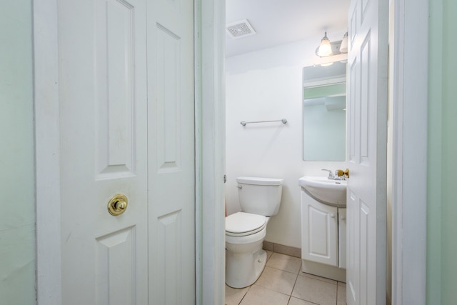 half bathroom with tile patterned flooring, visible vents, toilet, and vanity