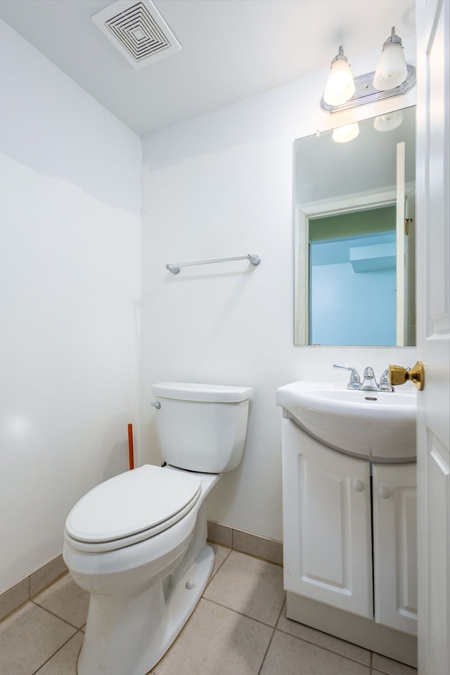 half bathroom featuring vanity, visible vents, baseboards, tile patterned flooring, and toilet