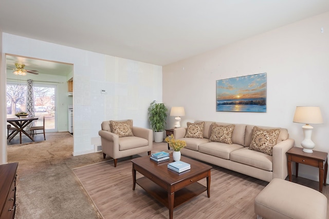 living area with light colored carpet and a ceiling fan