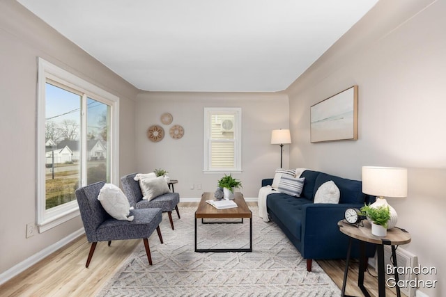 living area with light wood-type flooring and baseboards