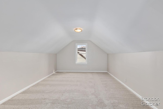 additional living space featuring lofted ceiling, carpet, and baseboards