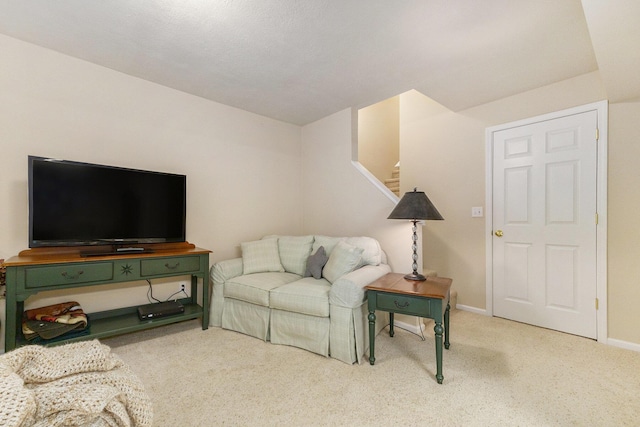 living area with stairs, baseboards, and carpet flooring