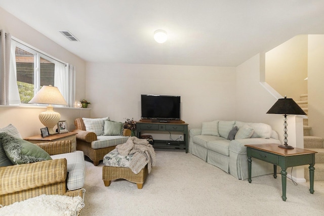 carpeted living room with stairway and visible vents