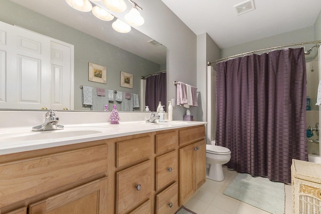 full bathroom with toilet, double vanity, visible vents, and a sink