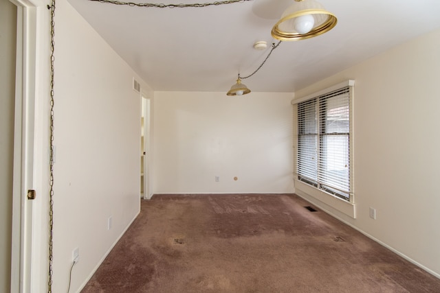 carpeted spare room featuring visible vents