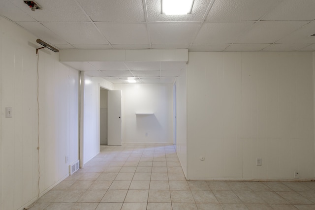 spare room featuring a drop ceiling, visible vents, and light tile patterned flooring