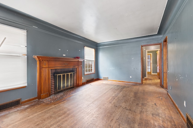 unfurnished living room featuring visible vents, a fireplace, baseboards, and hardwood / wood-style flooring