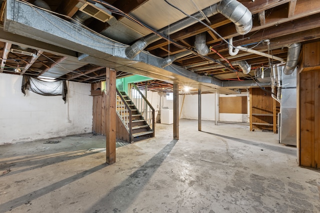 unfinished below grade area featuring stairway and washer / clothes dryer