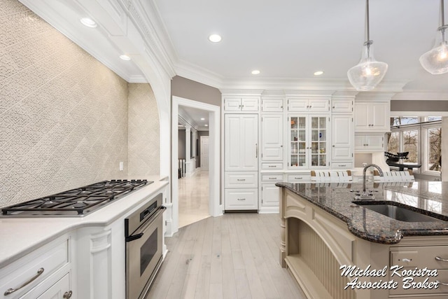 6862 Maplecrest Dr SE, Grand Rapids, MI 49546 - kitchen featuring crown molding, hanging light fixtures, appliances with stainless steel finishes, light wood-style floors, and a sink
